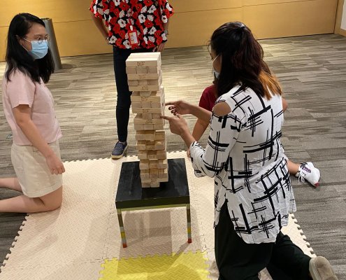 Participants challenging each other in a Giant Jenga game in Singapore, testing their steady hands and nerves.