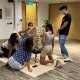 Adults enjoying a friendly game of Giant Jenga in Singapore, creating suspense and excitement with each turn.