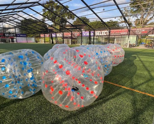Inflatable bubble soccer balls arranged on the field at The Cage, Singapore