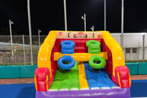 Inflatable basketball game setup at Sengkang Hockey Stadium Pitch, Singapore featuring four colorful pop-a-shot hoops and a vibrant design, perfect for engaging fast-paced fun at events for all ages.