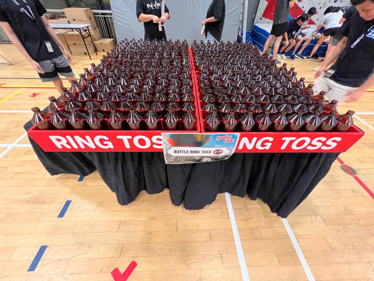 Bottle ring toss game setup with glass bottles and rings at SUTD Indoor Sports, Singapore.