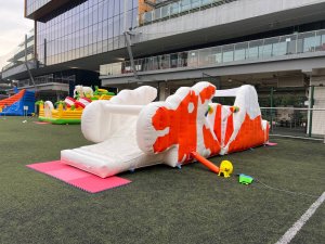 Vintage Dragon Playground inflatable at Tanglin Trust School in Singapore, designed with a white body and bright orange dragon-shaped features.
