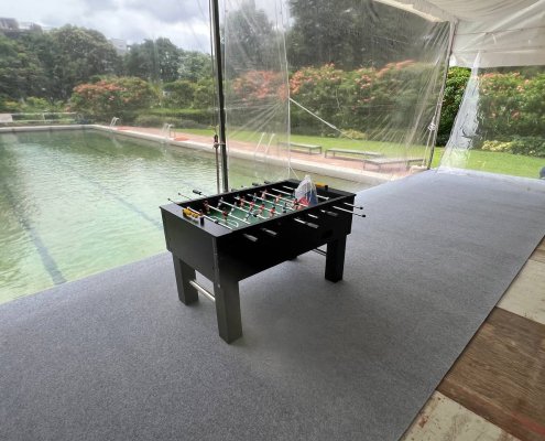 Classic foosball table with red and blue teams arranged on rods, set up at Goodwood Hill, Singapore.