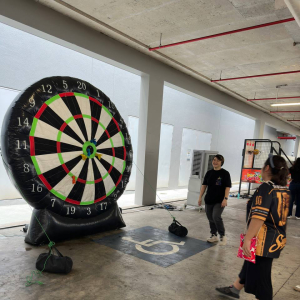Large inflatable dart game at Green Forest Park in Singapore, with participants aiming suction darts at an oversized dartboard target.