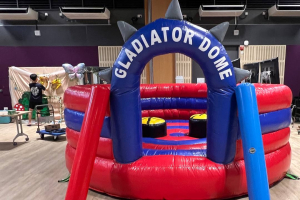 Gladiator Dome inflatable game setup at Lower Kent Ridge Rd in Singapore, with two raised platforms inside a round soft arena.