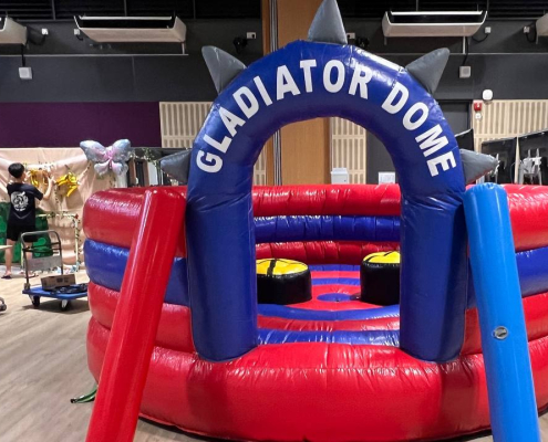 Gladiator Dome inflatable game setup at Lower Kent Ridge Rd in Singapore, with two raised platforms inside a round soft arena.