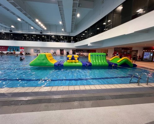The Drill as part of a larger inflatable water obstacle course, connecting seamlessly with other fun and challenging sections.