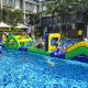 Children climbing up the Hill using blue handles before sliding down the opposite side into the water.