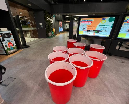 Human size beer pong setup with large buckets placed indoor at Novena Office Tower, Singapore.
