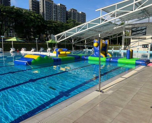 A playful water inflatable called the Hump, featuring a series of soft, bouncy waves for participants to walk or run across.