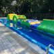 Side view of the Hump inflatable obstacle, highlighting its smooth wave-like shape and vibrant blue, yellow, and green colors.