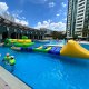 A floating inflatable challenge called the Hurdle, with long green side supports and three narrow crossing poles.