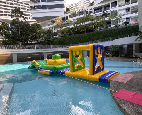 Man in Wall inflatable obstacle with two human-shaped cutouts for participants to pass through on a water course.