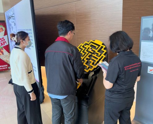 Maze Runner game at Singapore Health Services, Singapore, with participants working together to guide the ball through the maze.