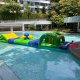 Mill - The Interlace The Mill inflatable obstacle with a blue center pole and four yellow poles extending outward, part of a water obstacle course.