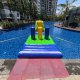 Front view of the Pillars section on a water obstacle course, showing wide gaps between the three colorful inflatable columns.