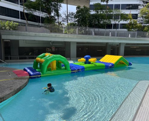 Side view of the Slide obstacle showing its symmetrical incline and decline, floating on the water.