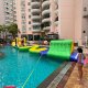 A yellow inflatable water obstacle shaped with wavy curves, designed to challenge players to walk carefully along its twisting path.