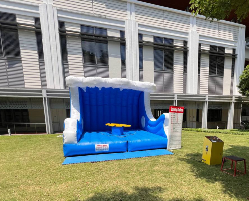 Surf board inflatable game at College Ave West, Singapore, with a moving surf board on top of a colorful inflatable base