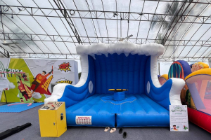 Surf board game setup at Siloso Beach Walk, Singapore, showing a surf board placed on an inflatable surface.