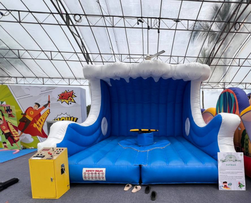 Surf board game setup at Siloso Beach Walk, Singapore, showing a surf board placed on an inflatable surface.