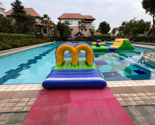 Curved inflatable water obstacle named Tunnel, used for crawling and ducking through during water games.