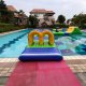 Curved inflatable water obstacle named Tunnel, used for crawling and ducking through during water games.