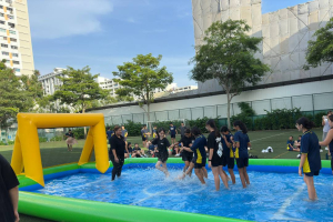 Water Soccer - Bishan Street 2 A group of students at Bishan Street, Singapore playing an energetic match of water soccer on a blue and yellow inflatable arena under the sunny skies of Singapore.