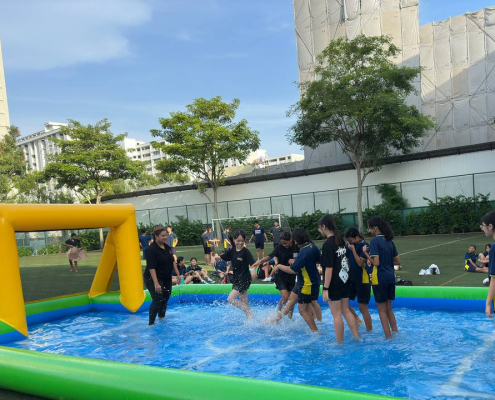 Water Soccer - Bishan Street 2 A group of students at Bishan Street, Singapore playing an energetic match of water soccer on a blue and yellow inflatable arena under the sunny skies of Singapore.