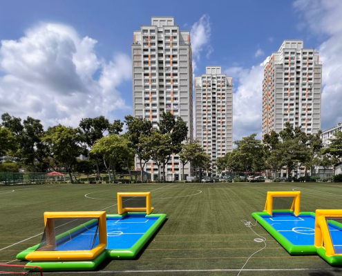 Water Soccer - Bishan Street 3 Two blue and yellow inflatable water soccer fields set up outdoors under a bright sky at Bishan Street, Singapore.