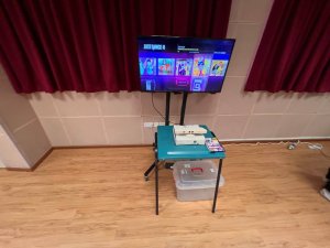 A Kinect gaming setup with a motion-sensing camera placed below a TV screen displaying a dance game, ready for hands-free play at Bedok South Secondary School, Singapore.