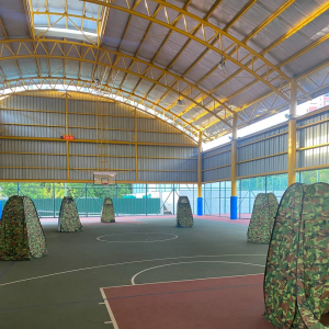 A group of medium-sized laser tag tents with camouflage patterns, arranged side by side and ready for gameplay at Tampines Meridien Junior College, Singapore.