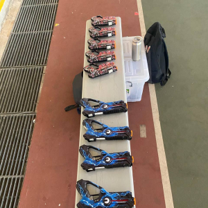 Multiple laser tag guns in bright blue and red colors neatly displayed on a table, prepared for players at Tampines Meridian Junior College, Singapore.