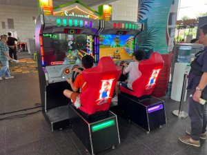 Two players racing on Mario Kart arcade at National Library Building, Singapore event setup