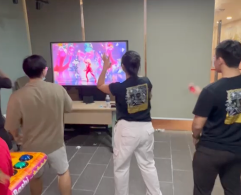 Four people playing Just Dance on a Nintendo Switch station with TV at an event.