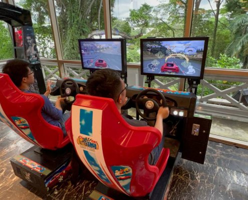 Guests playing the iconic Outrun driving arcade machine at Fort Canning Hotel, Singapore