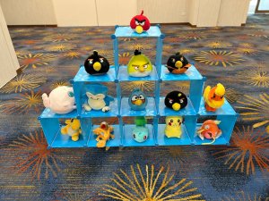 “Close-up of Pokemon Catch game booth at OCC Singapore with colorful dolls stacked for players to hit with Poké Balls.