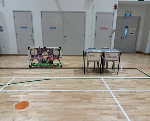 The Super Goal game station with a goalpost and a cover displaying five holes, encouraging players to score through the targets at Shuqun Primary School.