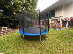 A sturdy blue trampoline with a safety net enclosure, placed outdoors and ready for rent at Allanbrooke Road, Singapore.