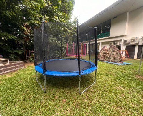 A sturdy blue trampoline with a safety net enclosure, placed outdoors and ready for rent at Allanbrooke Road, Singapore.
