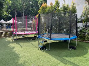 A child-friendly trampoline with soft padding and a net enclosure in blue and pink tones, set up at Allanbrooke Road, Singapore.