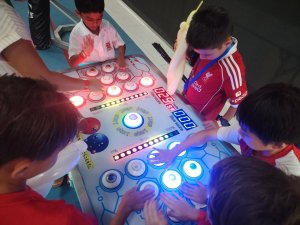 Children playing Naughty Beans carnival toss game at an indoor party