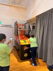 Teen playing Basketball Legend arcade machine at indoor carnival setup